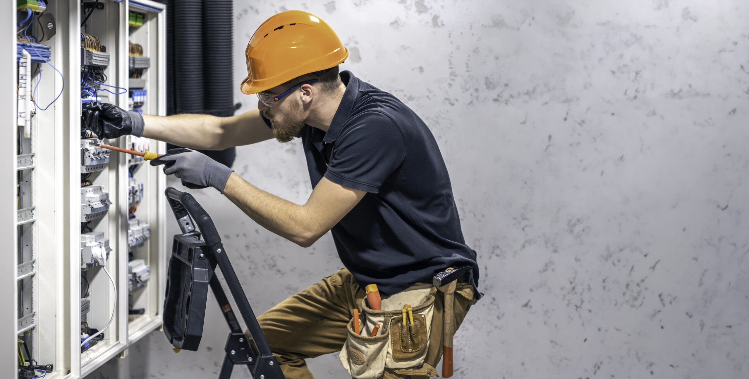 Electricista certificado con equipo de seguridad realizando labores técnicas